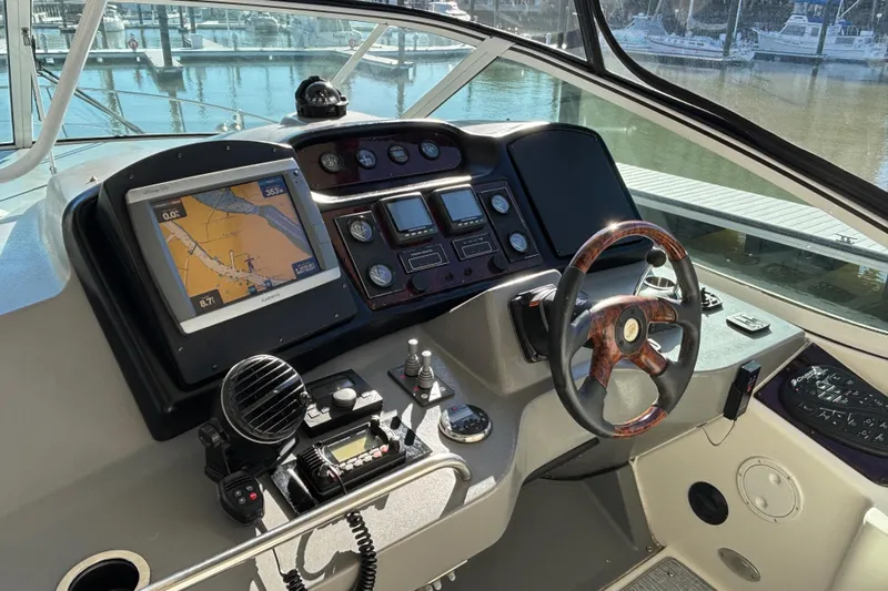 Liberty Call Yacht Photos Pics 2005 Cruisers Yachts 455 Express Motoryacht helm with navigation equipment and wooden steering wheel.