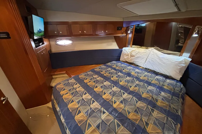 Liberty Call Yacht Photos Pics Luxurious forward stateroom in 2005 Cruisers Yachts 455 Express Motoryacht with cozy bedding and wood accents.