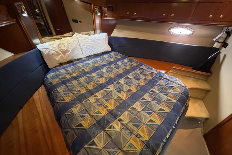 Liberty Call Yacht Photos Pics Luxurious bedroom interior of 2005 Cruisers Yachts 455 Express Motoryacht with geometric bedspread.