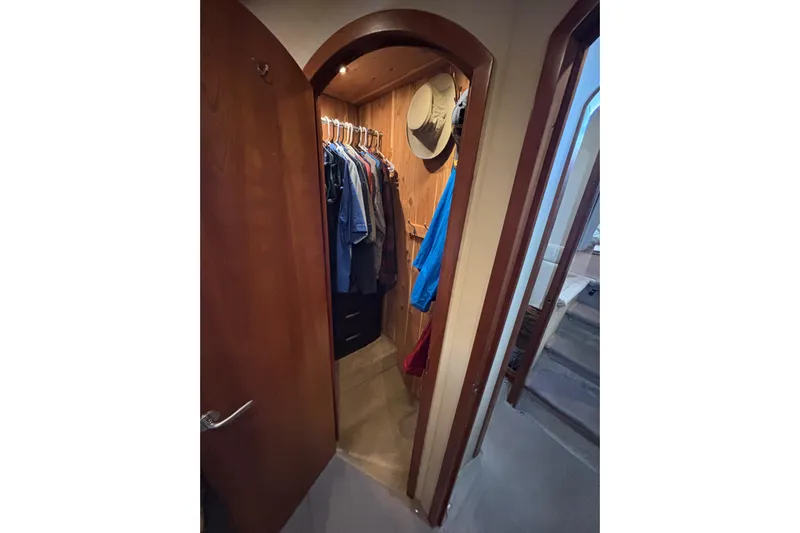 Liberty Call Yacht Photos Pics Walk-in closet on 2005 Cruisers Yachts 455 Express Motoryacht with hanging clothes and hats.