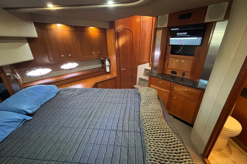 Liberty Call Yacht Photos Pics Luxurious 2005 Cruisers Yachts 455 Express Motoryacht bedroom with wood cabinetry and modern amenities.