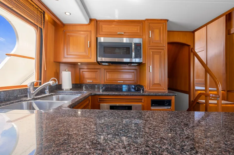  Yacht Photos Pics Luxurious kitchen interior of 2007 Fleming 65 yacht with wooden cabinetry and granite countertops.