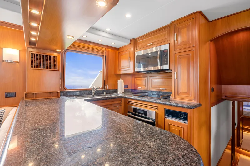  Yacht Photos Pics Luxurious kitchen interior of a 2007 Fleming 65 yacht with wooden cabinetry and granite countertops.