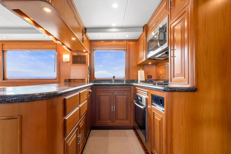  Yacht Photos Pics Luxurious kitchen interior of 2007 Fleming 65 yacht with wooden cabinetry and modern appliances.