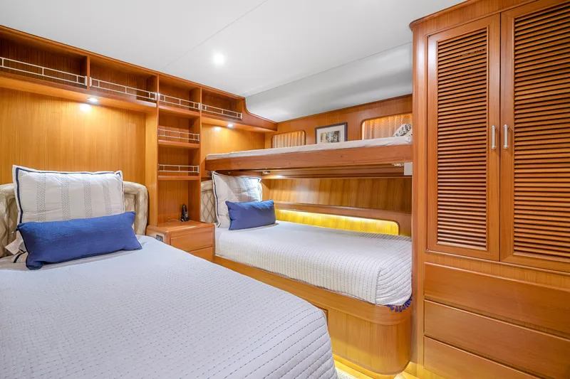  Yacht Photos Pics Luxurious cabin interior of 2007 Fleming 65 yacht with wooden furnishings and cozy bedding.