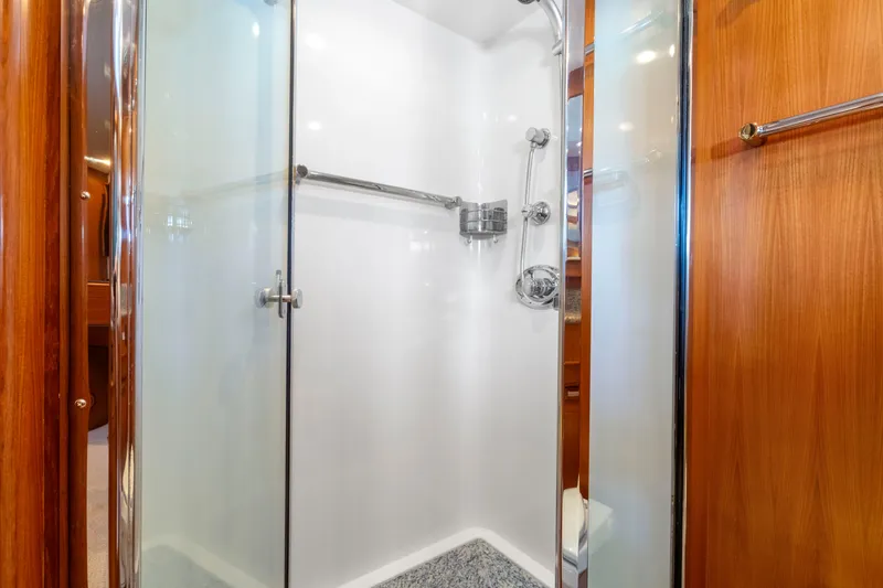  Yacht Photos Pics Luxurious shower in 2007 Fleming 65 yacht with glass doors and wooden accents.