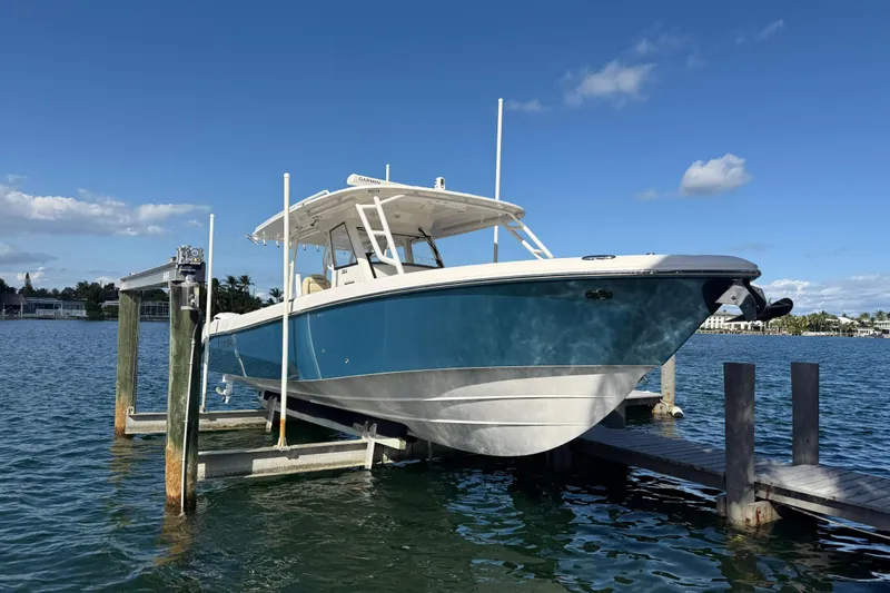  Yacht Photos Pics 2018 Everglades 355 Center Console boat on lift, blue sky background.
