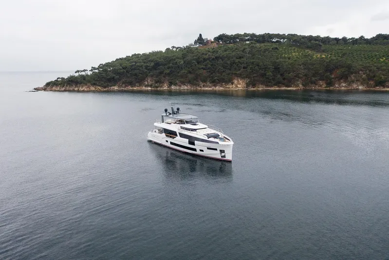  Yacht Photos Pics Luxury 2023 Sirena 88 yacht cruising near a lush, green island.