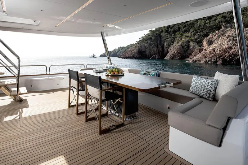  Yacht Photos Pics Luxurious 2023 Sirena 88 yacht deck with elegant seating, ocean view, and coastal backdrop.