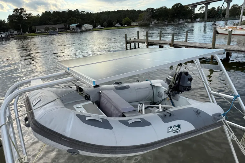 Fine Romance Yacht Photos Pics Inflatable boat with solar panel and outboard motor, docked near a Beneteau Oceanis 40 CC, 1997.