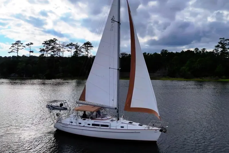 Fine Romance Yacht Photos Pics 1997 Beneteau Oceanis 40 CC sailboat on a serene lake under cloudy skies.