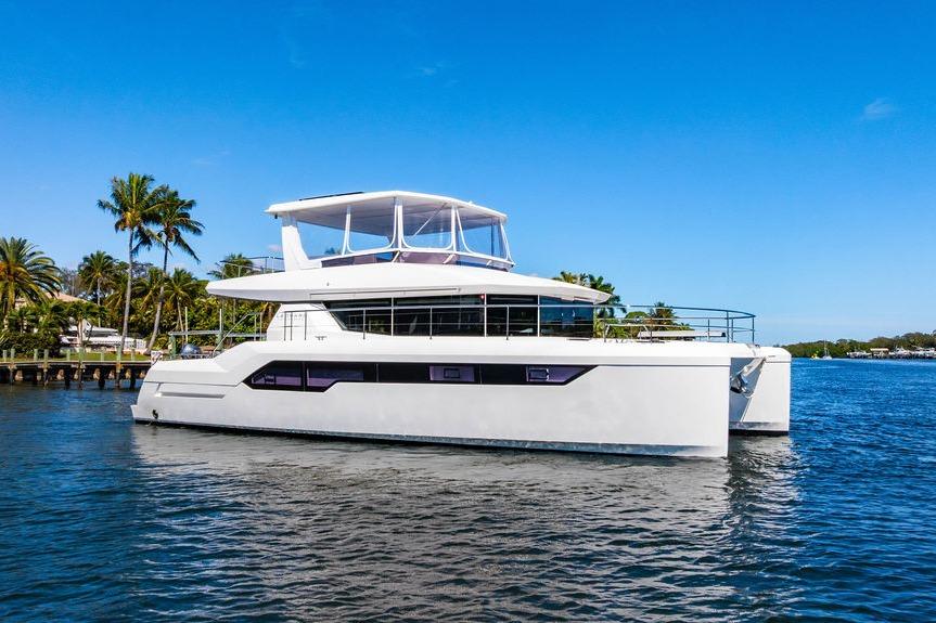 2022 Leopard 53 Powercat yacht on a sunny day, cruising near palm trees.