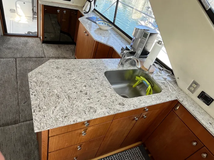  Yacht Photos Pics Kitchen area of 1996 Bayliner 3788 Command Bridge Motoryacht with granite countertops and wooden cabinets.