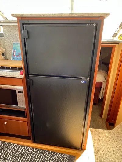  Yacht Photos Pics 1996 Bayliner 3788 Command Bridge Motoryacht interior with black fridge and microwave.