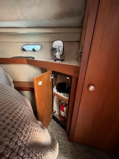  Yacht Photos Pics 1996 Bayliner 3788 Command Bridge Motoryacht cabin with open wooden cabinet and fire extinguisher.