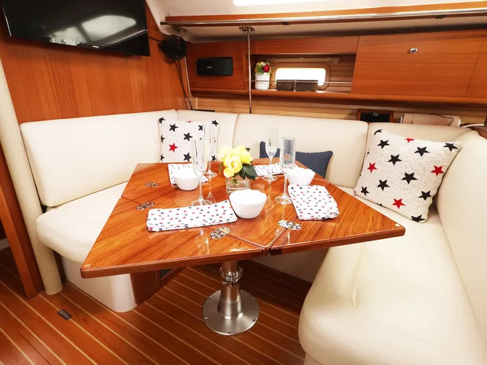  Yacht Photos Pics Elegant dining area in 2021 Catalina C355 yacht with wooden table and star-patterned cushions.