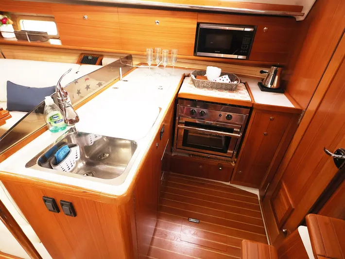  Yacht Photos Pics 2021 Catalina C355 yacht kitchen with wooden cabinetry, stainless steel sink, and modern appliances.