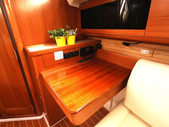  Yacht Photos Pics 2021 Catalina C355 yacht interior with wooden desk, plants, and seating.