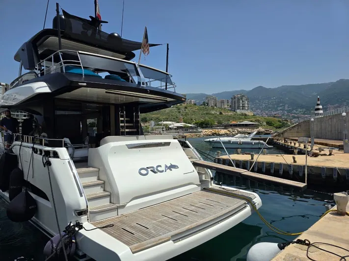  Yacht Photos Pics 2023 Cranchi Sessantasette 67 yacht docked at a marina with scenic mountain backdrop.