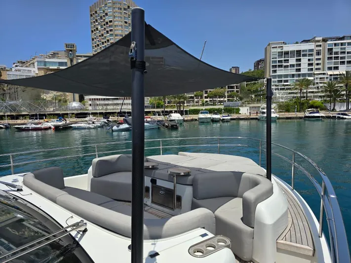  Yacht Photos Pics 2023 Cranchi Sessantasette 67 yacht with shaded deck, docked in a marina.