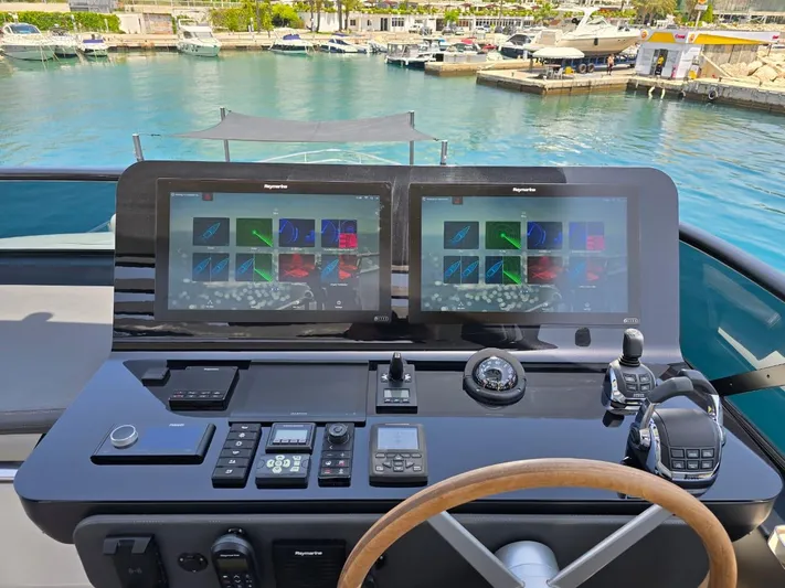  Yacht Photos Pics Control panel of 2023 Cranchi Sessantasette 67 yacht with dual screens in marina.