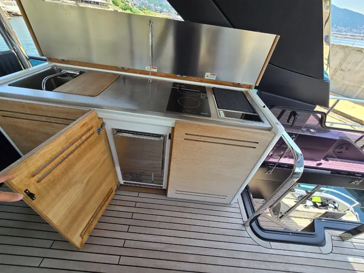  Yacht Photos Pics 2023 Cranchi Sessantasette 67 yacht kitchen with modern appliances and wooden cabinetry.