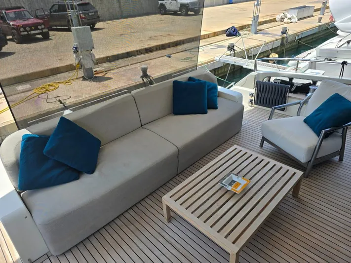  Yacht Photos Pics Luxury deck seating on 2023 Cranchi Sessantasette 67 yacht with blue cushions and wooden table.