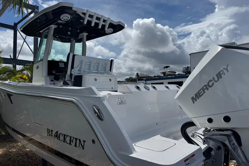  Yacht Photos Pics 2025 Blackfin 252 CC boat with Mercury engine under cloudy sky.
