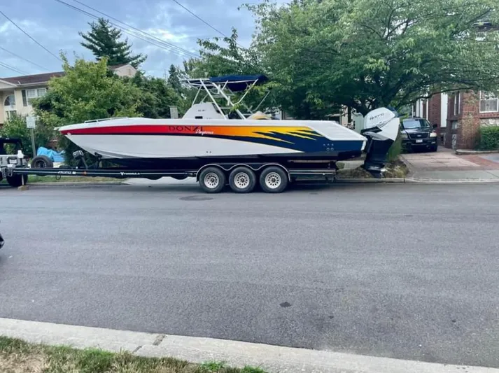  Yacht Photos Pics 2004 Donzi 35 ZF boat on trailer, parked on street, vibrant design.