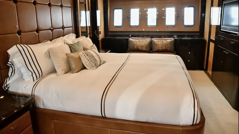 Yacht Photos Pics Luxurious bedroom interior of 2009 Mangusta 92 yacht with elegant bedding and porthole windows.