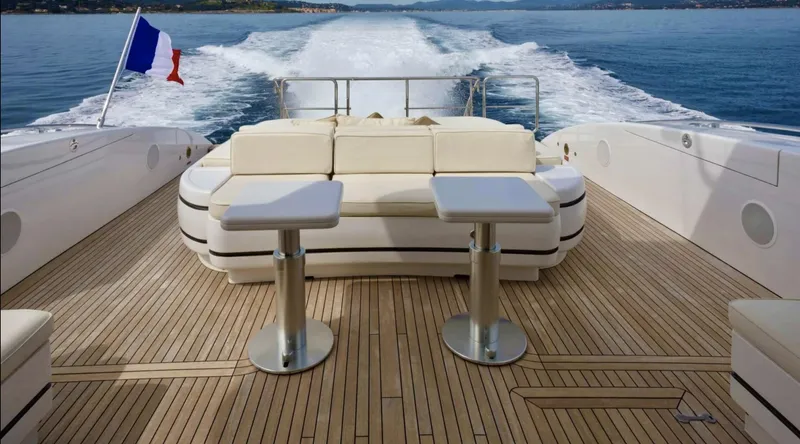 Yacht Photos Pics Luxurious 2009 Mangusta 92 yacht deck with seating, tables, and ocean view.