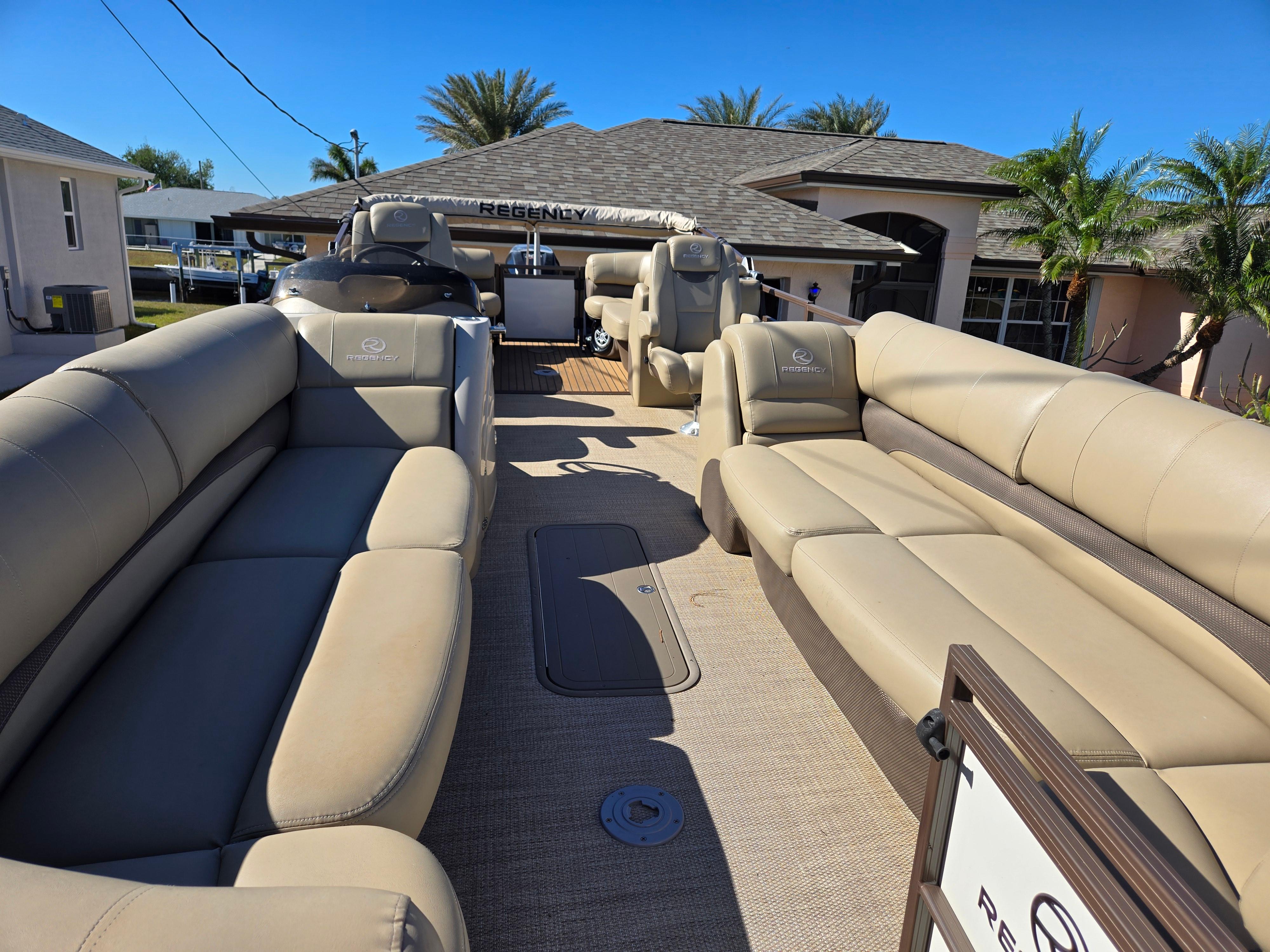 2017 Regency 254 LE3 pontoon boat with beige seating and spacious deck.
