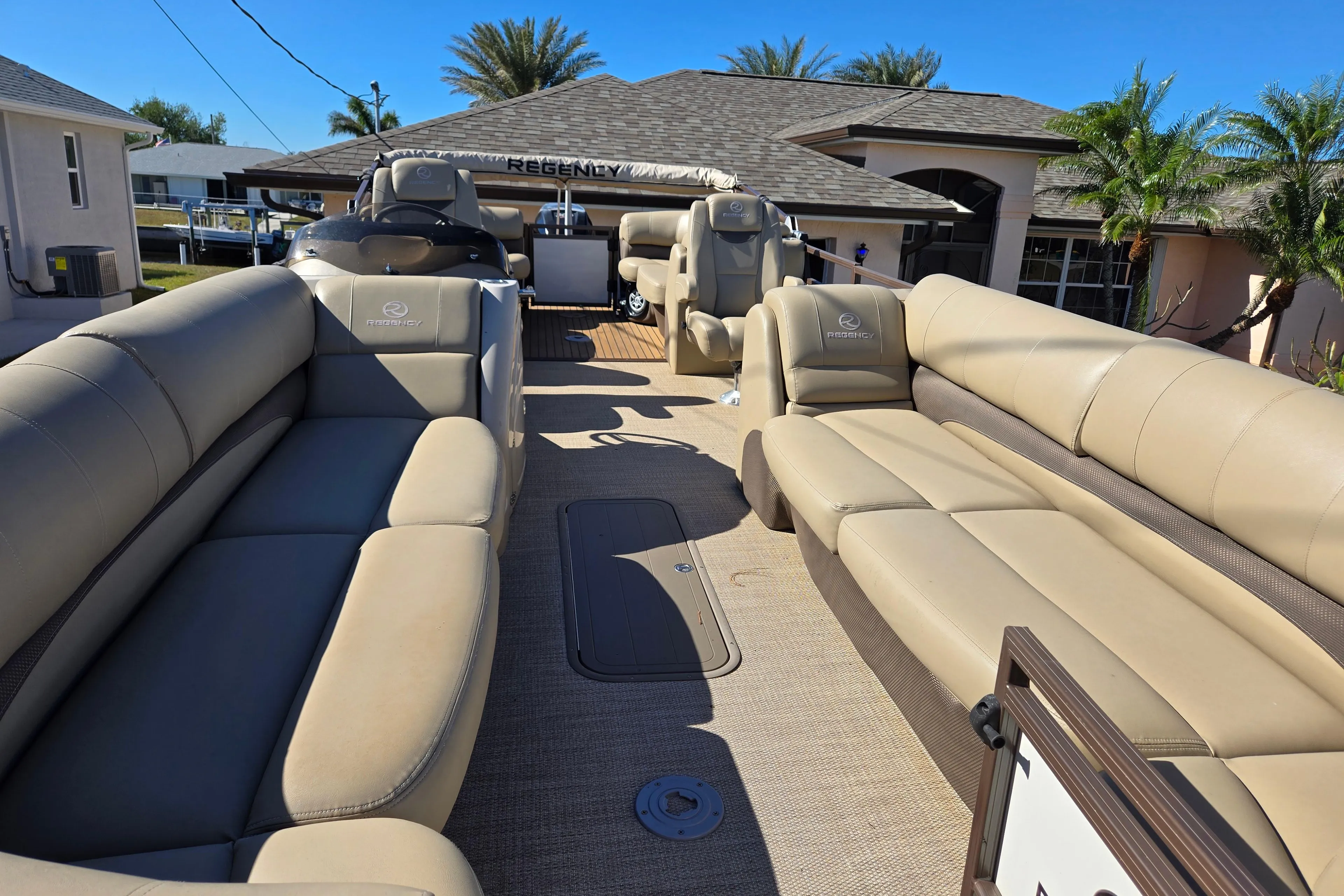 2017 Regency 254 LE3 pontoon boat with beige seating and spacious deck.