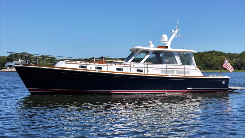 Ballena Yacht Photos Pics 2002 Grand Banks 49 Eastbay HX yacht on calm water, clear sky background.