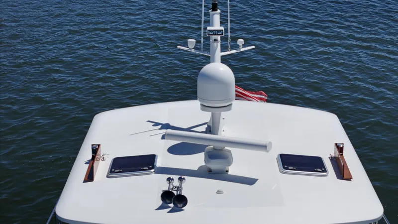 Ballena Yacht Photos Pics 2002 Grand Banks 49 Eastbay HX yacht roof with radar, vents, and flag on water.