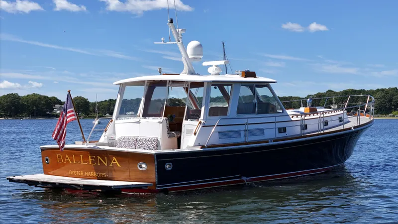 Ballena Yacht Photos Pics 2002 Grand Banks 49 Eastbay HX yacht on water, clear sky, American flag displayed.