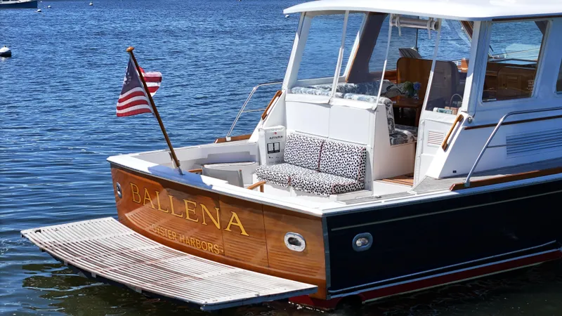 Ballena Yacht Photos Pics 2002 Grand Banks 49 Eastbay HX yacht with American flag, docked on calm water.