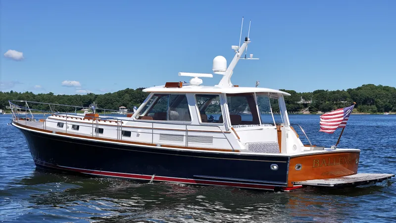 Ballena Yacht Photos Pics 2002 Grand Banks 49 Eastbay HX yacht on calm water with American flag.