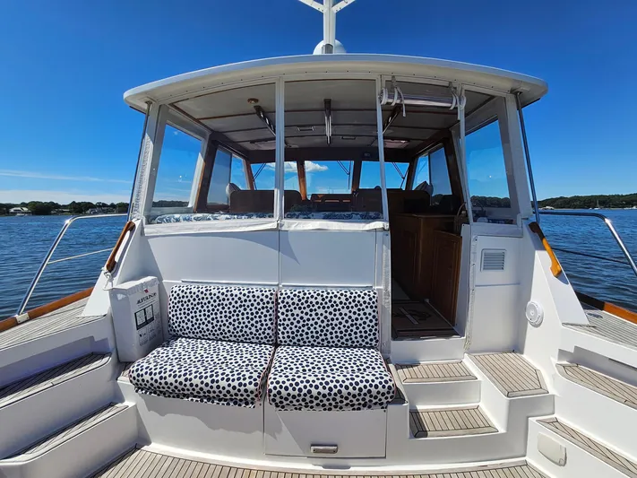 Ballena Yacht Photos Pics 2002 Grand Banks 49 Eastbay HX yacht with polka dot seating, docked on a sunny day.