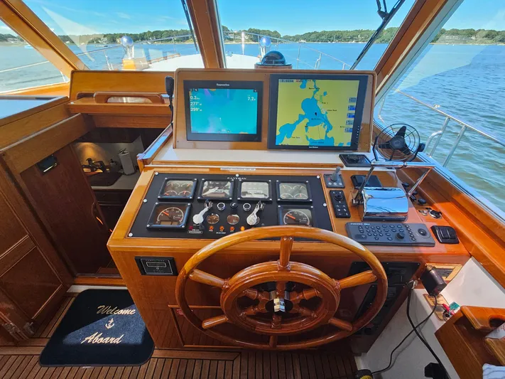Ballena Yacht Photos Pics Helm of 2002 Grand Banks 49 Eastbay HX with navigation screens and wooden steering wheel.