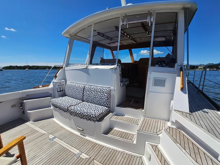 Ballena Yacht Photos Pics 2002 Grand Banks 49 Eastbay HX yacht with spacious deck and seating, docked on a sunny day.