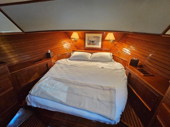 Ballena Yacht Photos Pics Luxurious cabin interior of 2002 Grand Banks 49 Eastbay HX yacht with cozy bed and warm lighting.