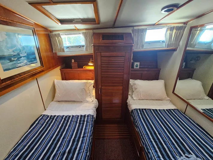 Ballena Yacht Photos Pics Twin cabin interior of 2002 Grand Banks 49 Eastbay HX yacht with striped bedding.