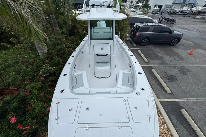  Yacht Photos Pics 2026 Blackfin 262 HB boat in parking lot, surrounded by greenery and vehicles.