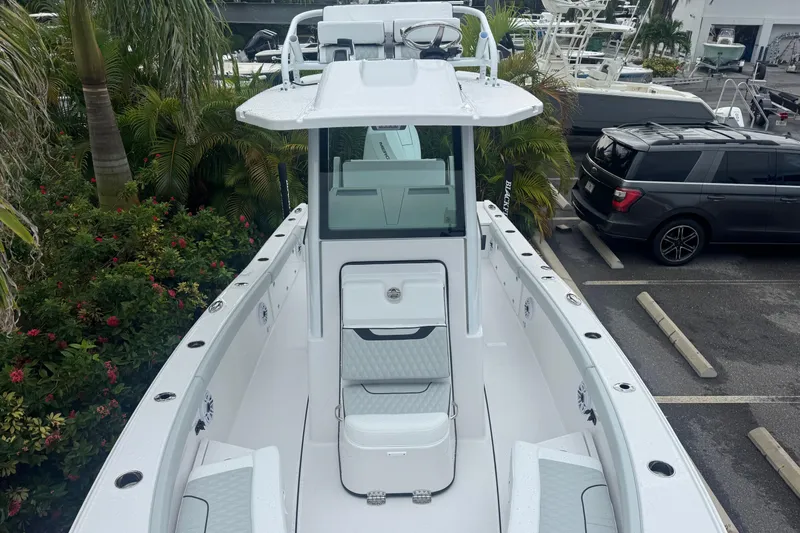  Yacht Photos Pics 2026 Blackfin 262 HB boat, sleek design, parked near lush greenery and vehicles.