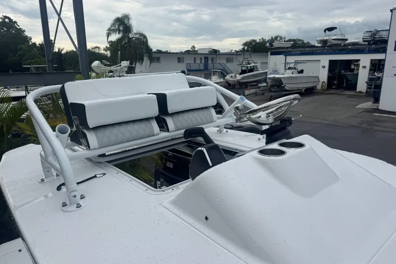  Yacht Photos Pics 2026 Blackfin 262 HB boat with sleek seating and steering wheel, docked at a marina.