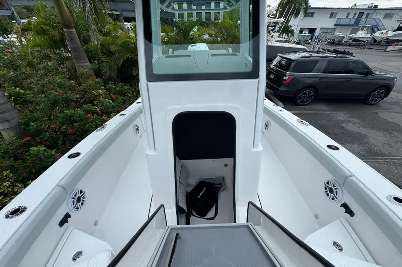  Yacht Photos Pics 2026 Blackfin 262 HB boat interior with open storage compartment, surrounded by lush greenery.
