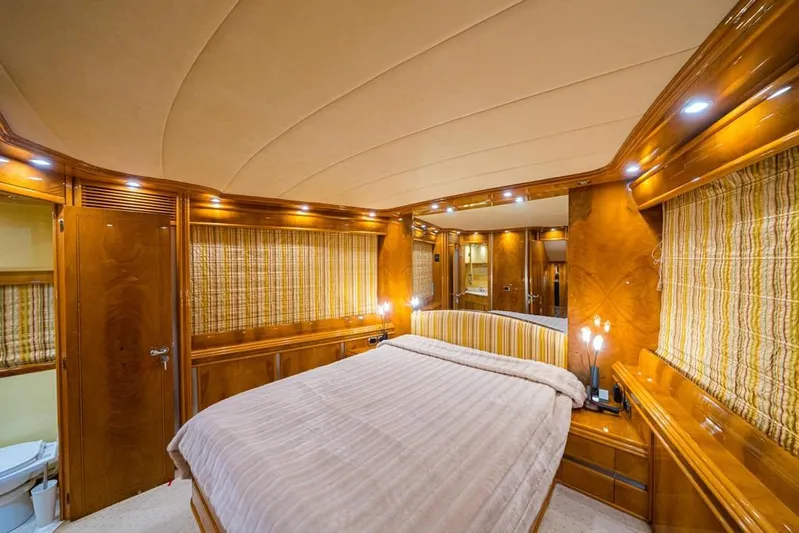  Yacht Photos Pics Luxurious bedroom interior of 2000 Astondoa 82 GLX yacht with wood paneling and ambient lighting.