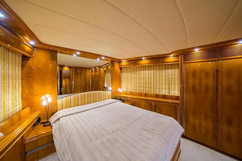  Yacht Photos Pics Luxurious bedroom interior of 2000 Astondoa 82 GLX yacht with wood paneling and ambient lighting.