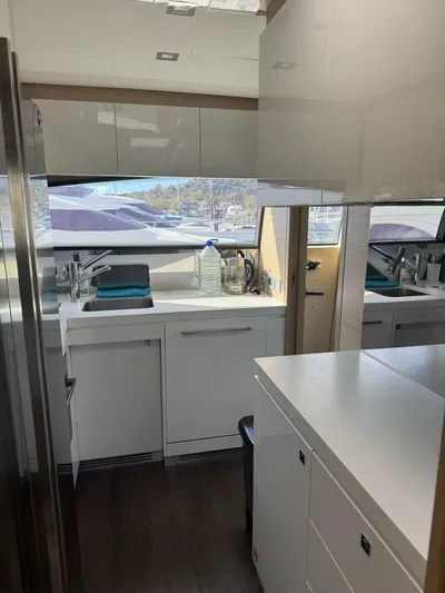  Yacht Photos Pics Modern kitchen interior of 2016 Ferretti Yachts 750, featuring sleek white cabinetry and appliances.